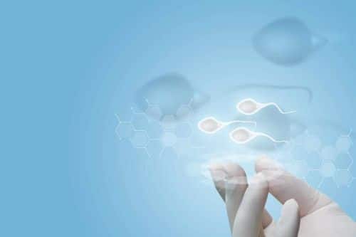 hand in a white latex glove on a background with digitally rendered sperm cells - legal rights of sperm donors concept